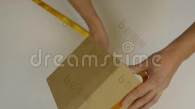 准备送礼物。 礼盒包装用金丝带.. 双手用黄色丝带包裹礼品盒